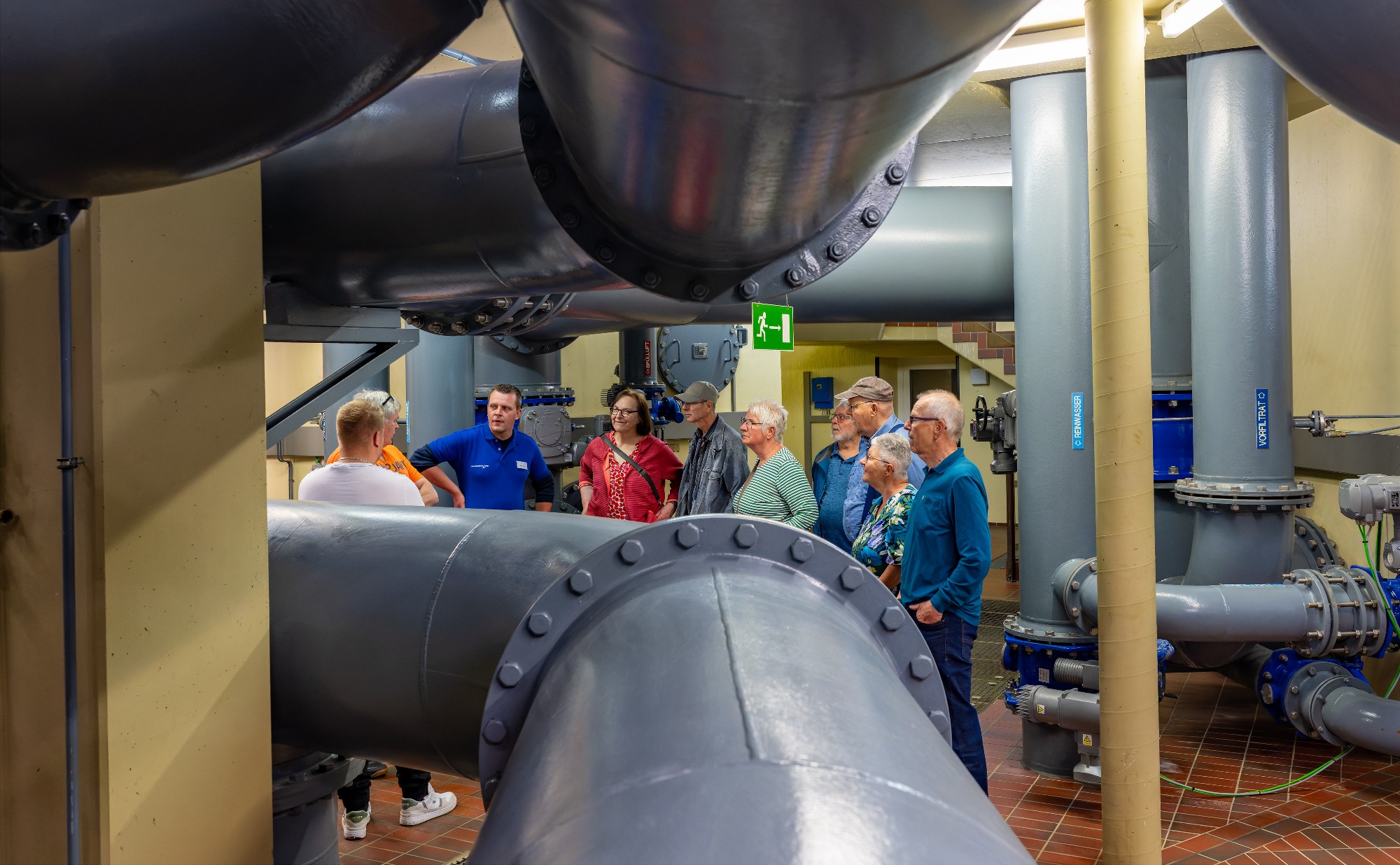 Ein Mitarbeiter des Trinkwasserverbandes führt eine Gruppe durch das Wasserwerk. 